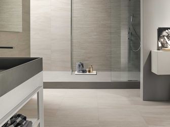 Mountain Beige en grès cérame effet pierre au mur comme au sol dans la salle de bain.