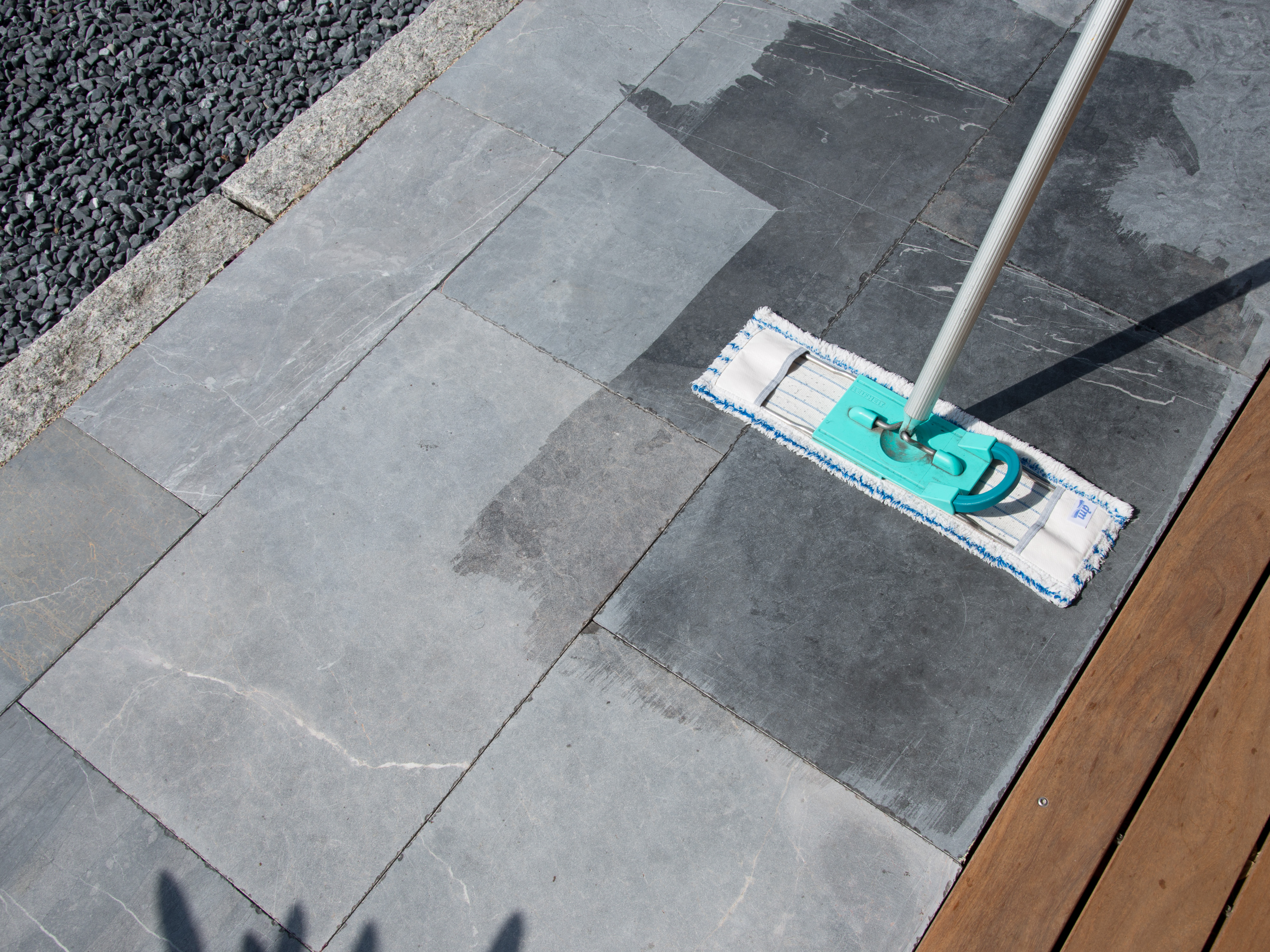 Balai à franges sur une terrasse en pierre calcaire