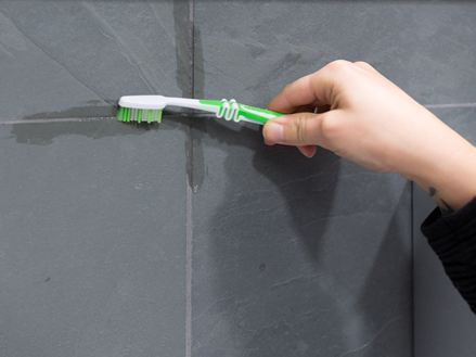 Fugen reinigen mit einer Zahnbürste